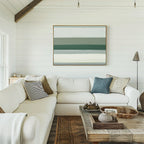 A bright living room with white shiplap walls, a large white sectional with assorted pillows, a rustic wood coffee table with decor, and the Sage Gradient Canvas Art - Horizontal displayed on the wall.