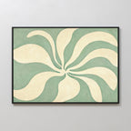 Sage Meditation Canvas Art – Horizontal showcases cream, petal-like shapes radiating from the center on a green background. This modern piece is framed in black and displayed on a light gray wall for contemporary style.