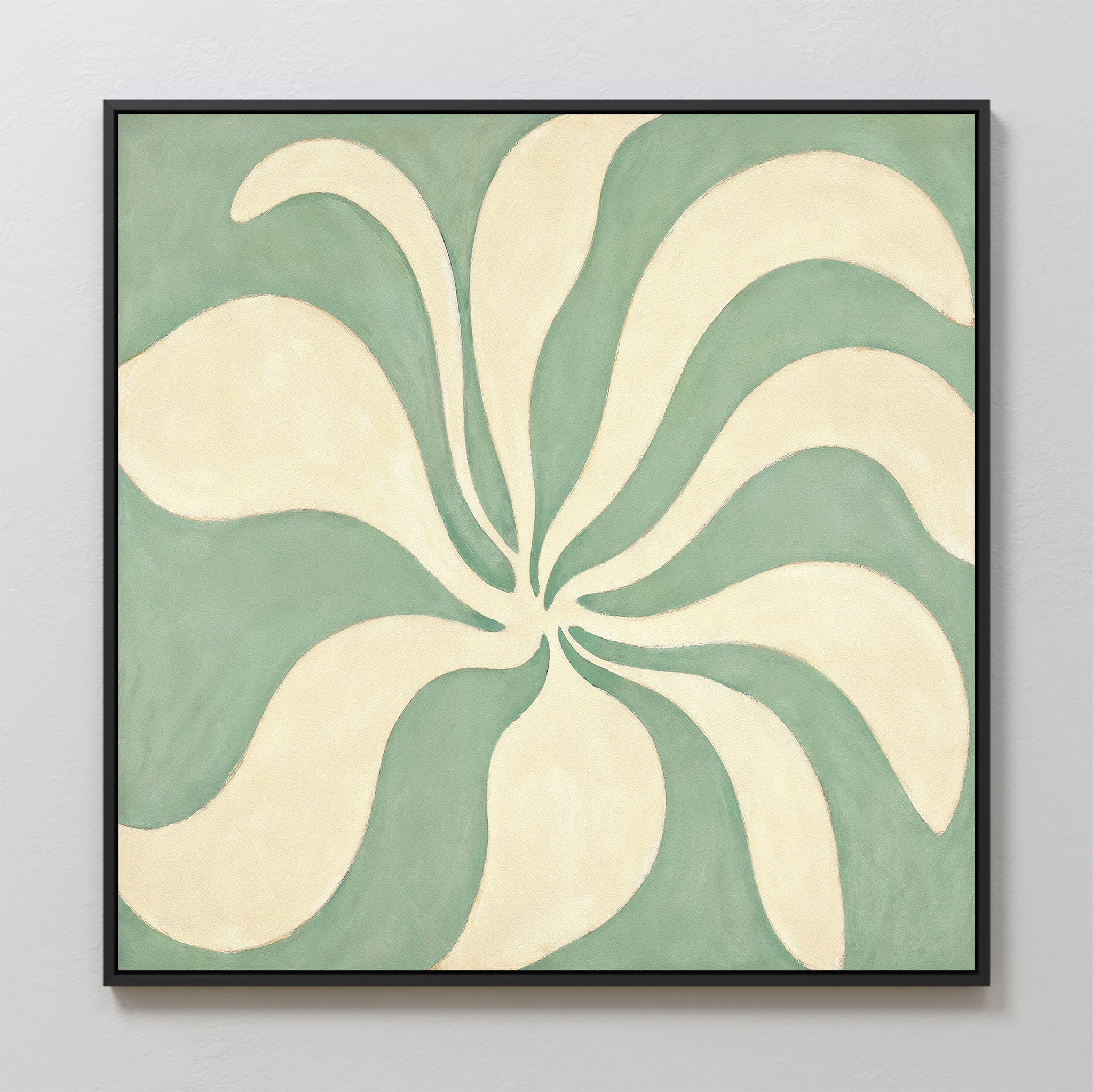 Sage Meditation Canvas Art - Square features cream, petal-like shapes radiating from the center on a muted green background, elegantly framed in black and showcased as striking sage green wall art against a light gray wall.
