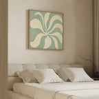 A modern bedroom with a beige upholstered bed, white bedding, four pillows, and the Sage Meditation Canvas Art - Square in sage green above the headboard. A bare branch decorates the nightstand beside floor-length curtains.