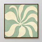 The Sage Meditation Canvas Art - Square features cream petal-like shapes radiating from a center on a muted sage green background, framed and displayed as elegant Nordic Park wall art on a light gray wall.