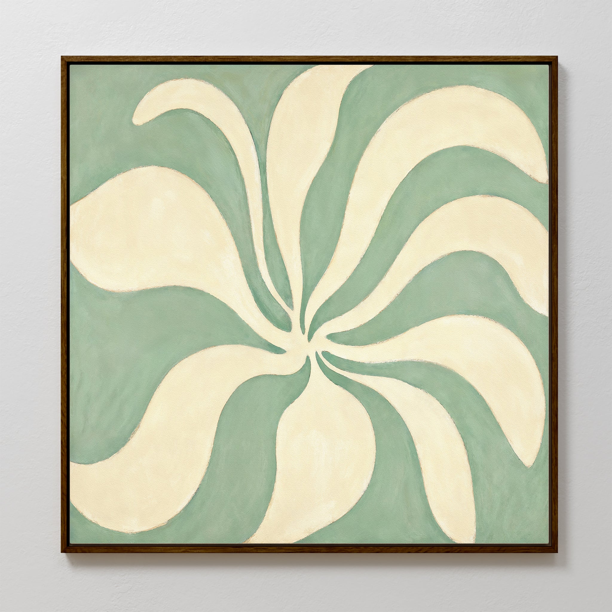 The Sage Meditation Canvas Art - Square features cream petal-like shapes radiating from a center on a muted sage green background, framed and displayed as elegant Nordic Park wall art on a light gray wall.