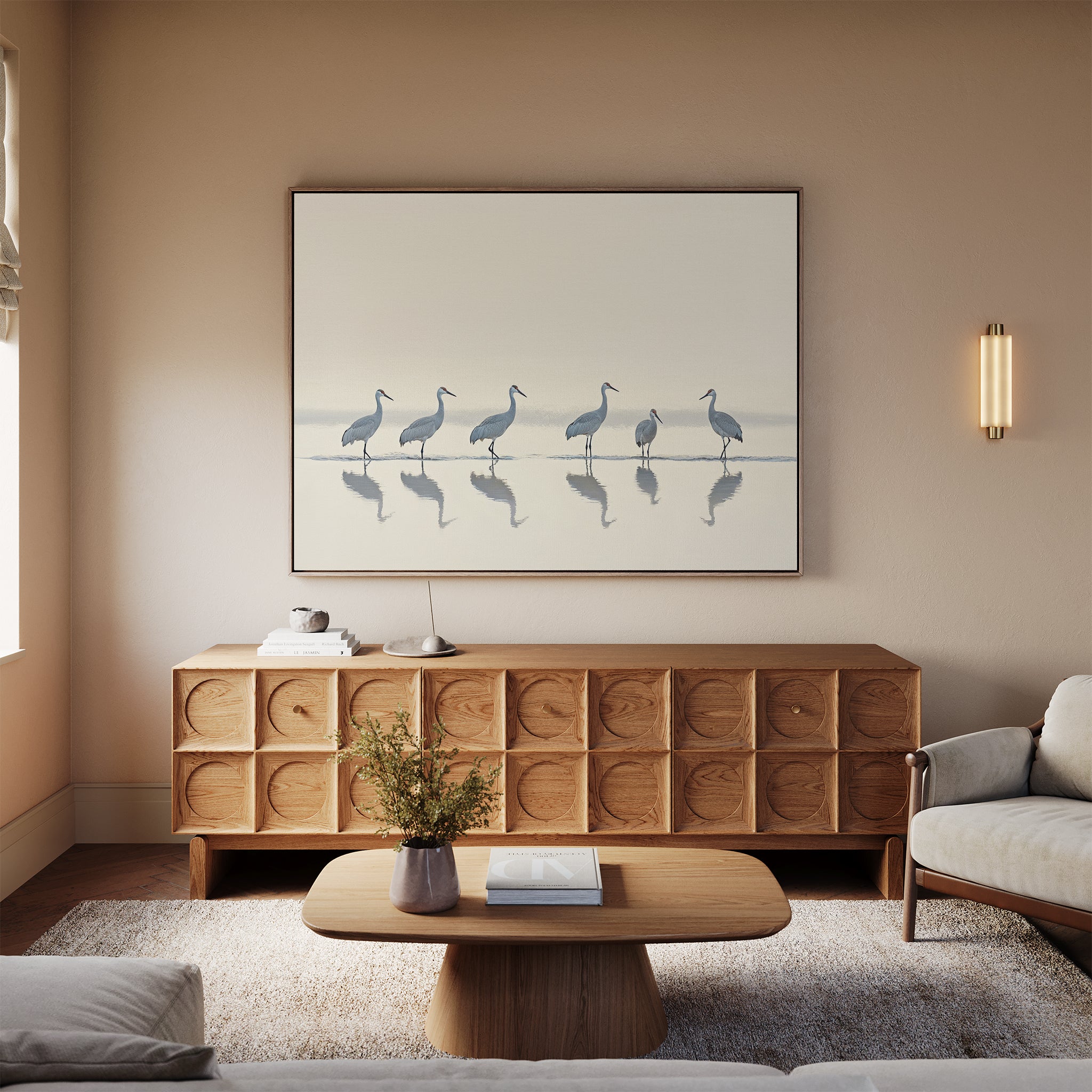 A minimalist living room with a light sofa, wooden coffee table, carved sideboard, vase of flowers, and the "Sandhill Procession Canvas Art - Horizontal" adds serene elegance. Neutral tones and soft lighting evoke a calm Nordic Park ambiance.