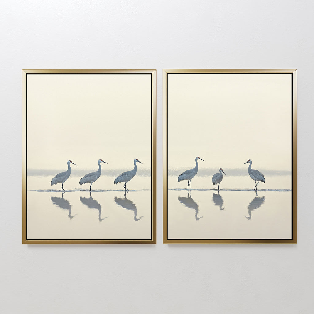 The "Sandhill Procession - Set of 2" features minimalist framed prints of cranes: one shows four walking, the other three standing and a smaller bird, their reflections mirrored in water—perfect serene decor for any space.