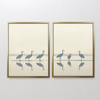 The "Sandhill Procession - Set of 2" features minimalist framed prints of cranes: one shows four walking, the other three standing and a smaller bird, their reflections mirrored in water—perfect serene decor for any space.