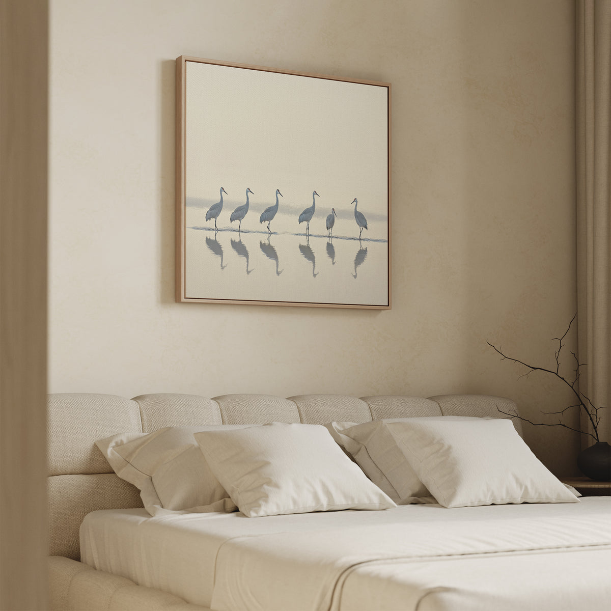 A minimalistic bedroom with a beige bed, white pillows, and the Sandhill Procession Canvas Art - Square above the headboard, featuring six cranes and their reflections for a calm and peaceful atmosphere.