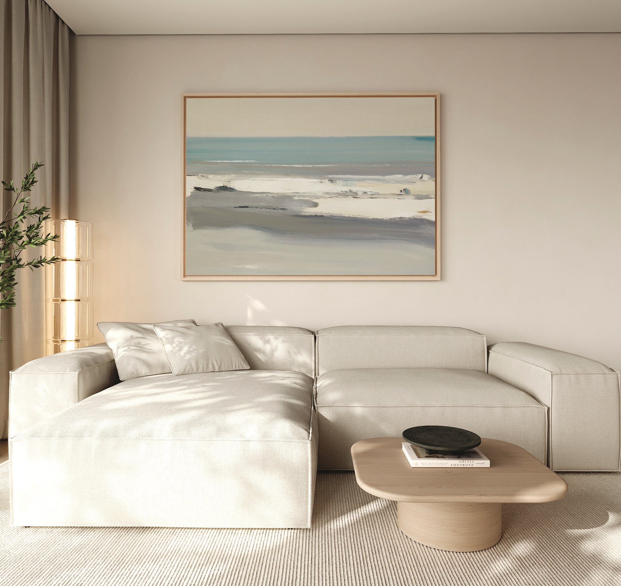 A modern living room features a beige sectional sofa, light wood coffee table, and the Sandy Retreat Canvas Art - Horizontal above. Soft natural light fills the space, with a green plant in the corner enhancing calming coastal vibes.