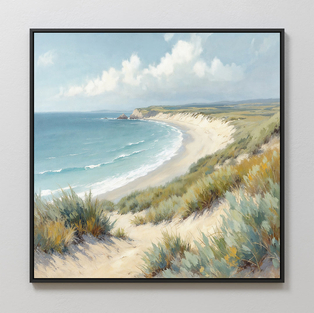 The Sandy Shores Canvas Art - Square features a coastal landscape with gentle waves, grassy dunes, and a partly cloudy sky, beautifully framed and displayed on a light-colored wall.