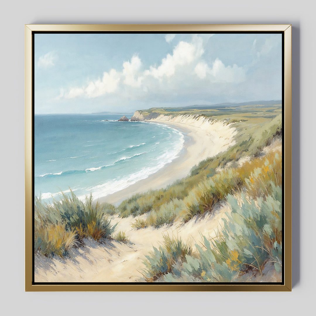 The Sandy Shores Canvas Art - Square features a sandy beach with gentle waves, grassy dunes, distant cliffs, and a blue sky with clouds—ideal wall art to bring a tranquil coastal vibe to any space.