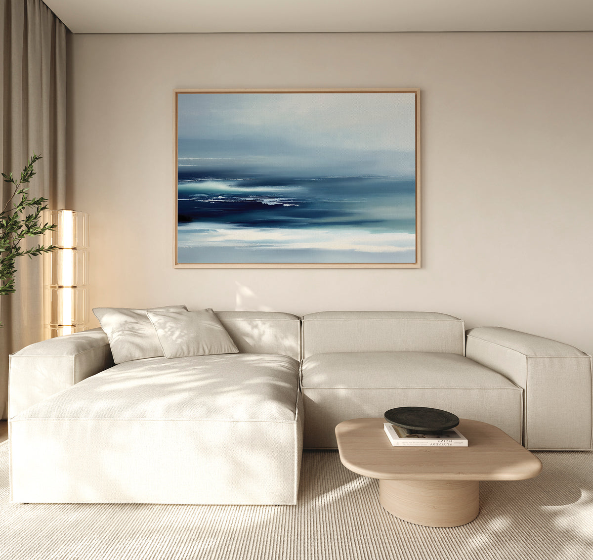 A modern living room with a light beige sectional, low wooden coffee table, and the Sapphire Current Canvas Art - Horizontal as tranquil wall décor. A potted plant sits in the corner with natural light filtering through beige curtains.