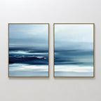 Sapphire Current - Set Of 2 features framed abstract prints with smooth blue and white gradients, evoking a tranquil seascape. Horizontal brushstrokes and soft blending create calming, modern wall art for any space.