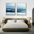 A modern bedroom with an olive green bed, white bedding, and beige nightstands is made serene by the Sapphire Current - Set Of 2 artwork, featuring large sapphire abstract prints hanging above the bed.