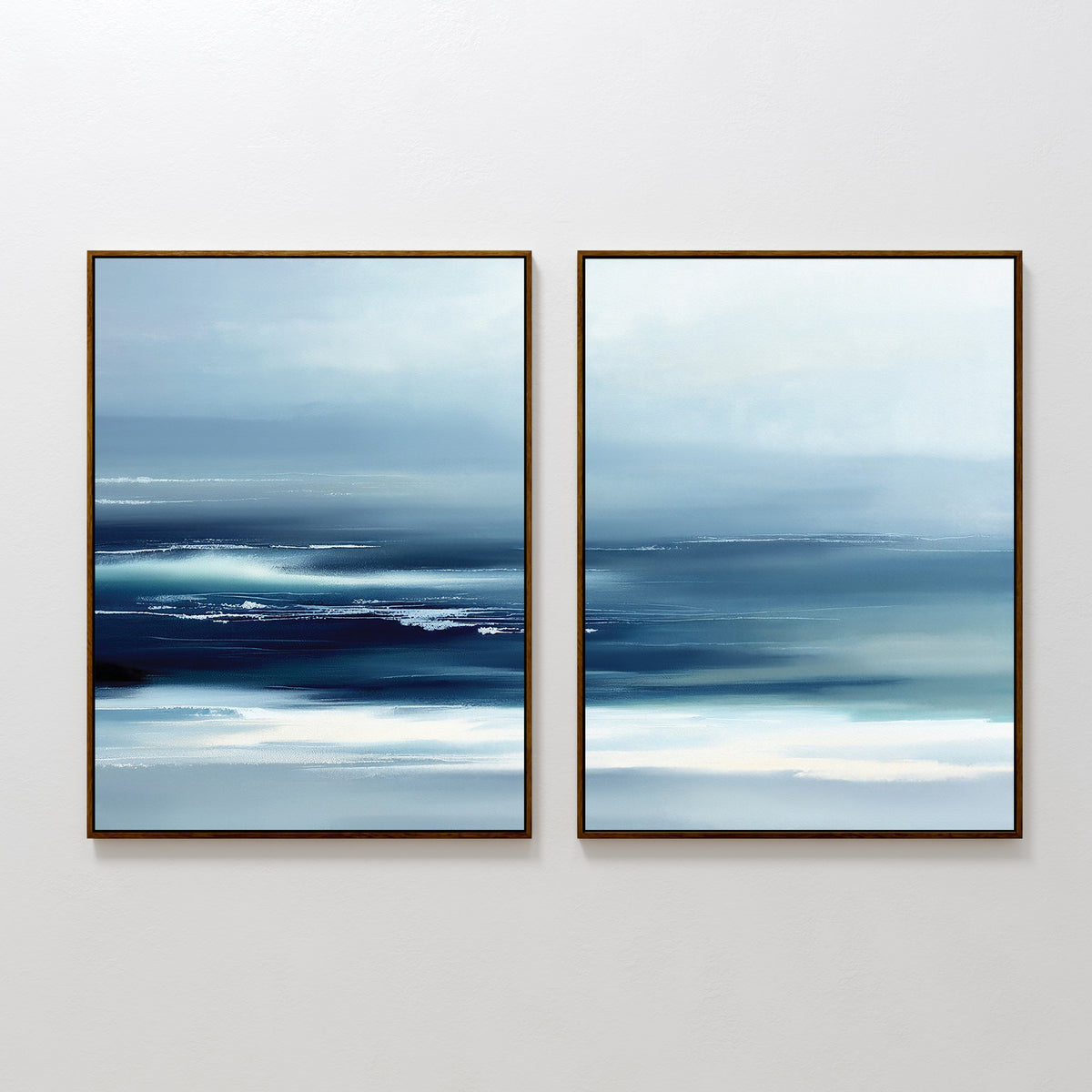 The Sapphire Current - Set Of 2 showcases abstract prints in blue and white with blurred horizontal lines, evoking a serene seascape. Each tranquil piece is framed in a slim dark frame and displayed side by side on a white wall.