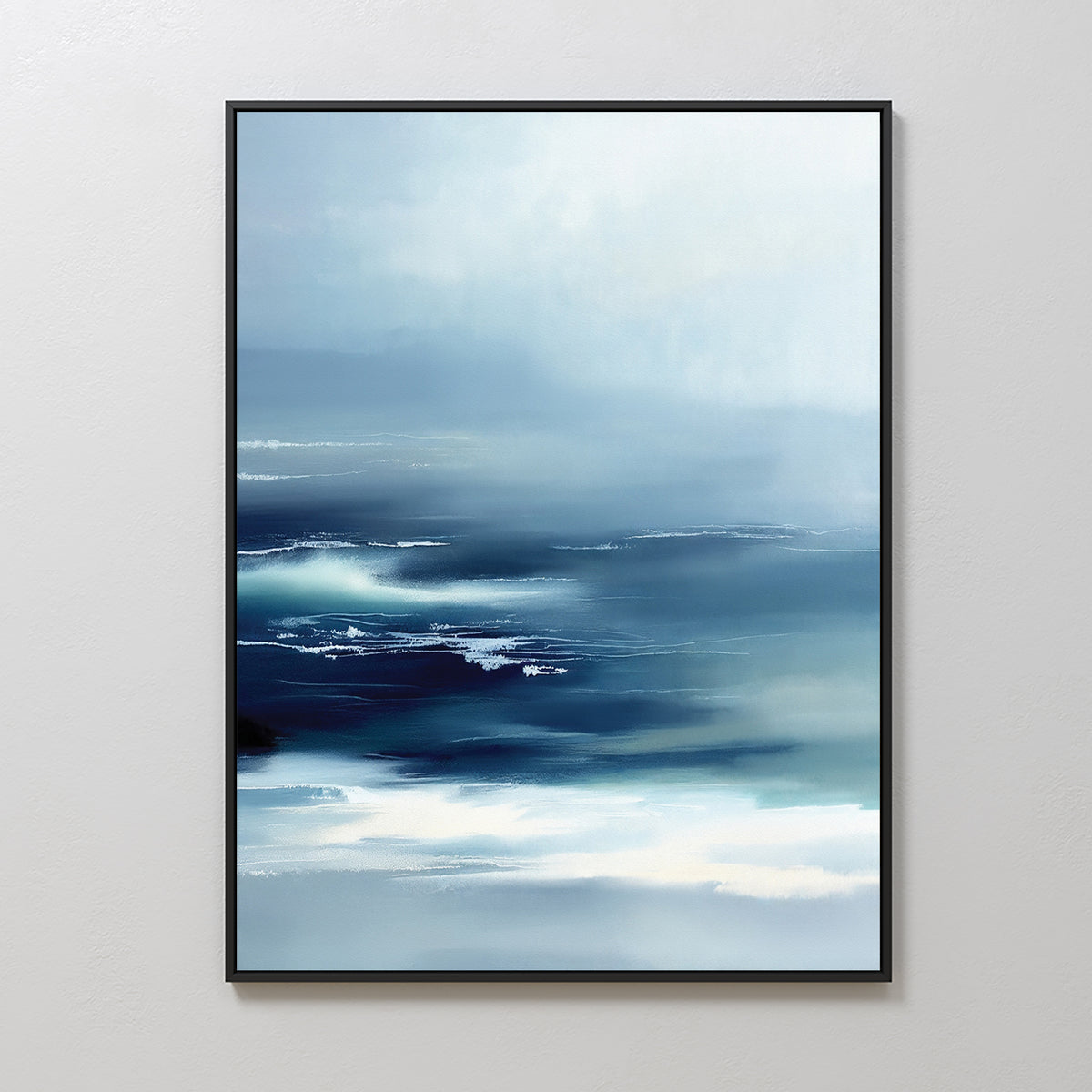 Sapphire Current Canvas Art - Vertical features abstract waves and mist in blue, white, and navy. This tranquil piece is framed in black and displayed on a neutral wall, bringing calm ocean vibes to any space.