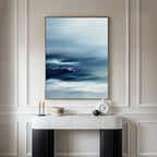 A minimalistic entryway is styled with a white console table, modern decor, and the Sapphire Current Canvas Art - Vertical displayed on the beige paneled wall.