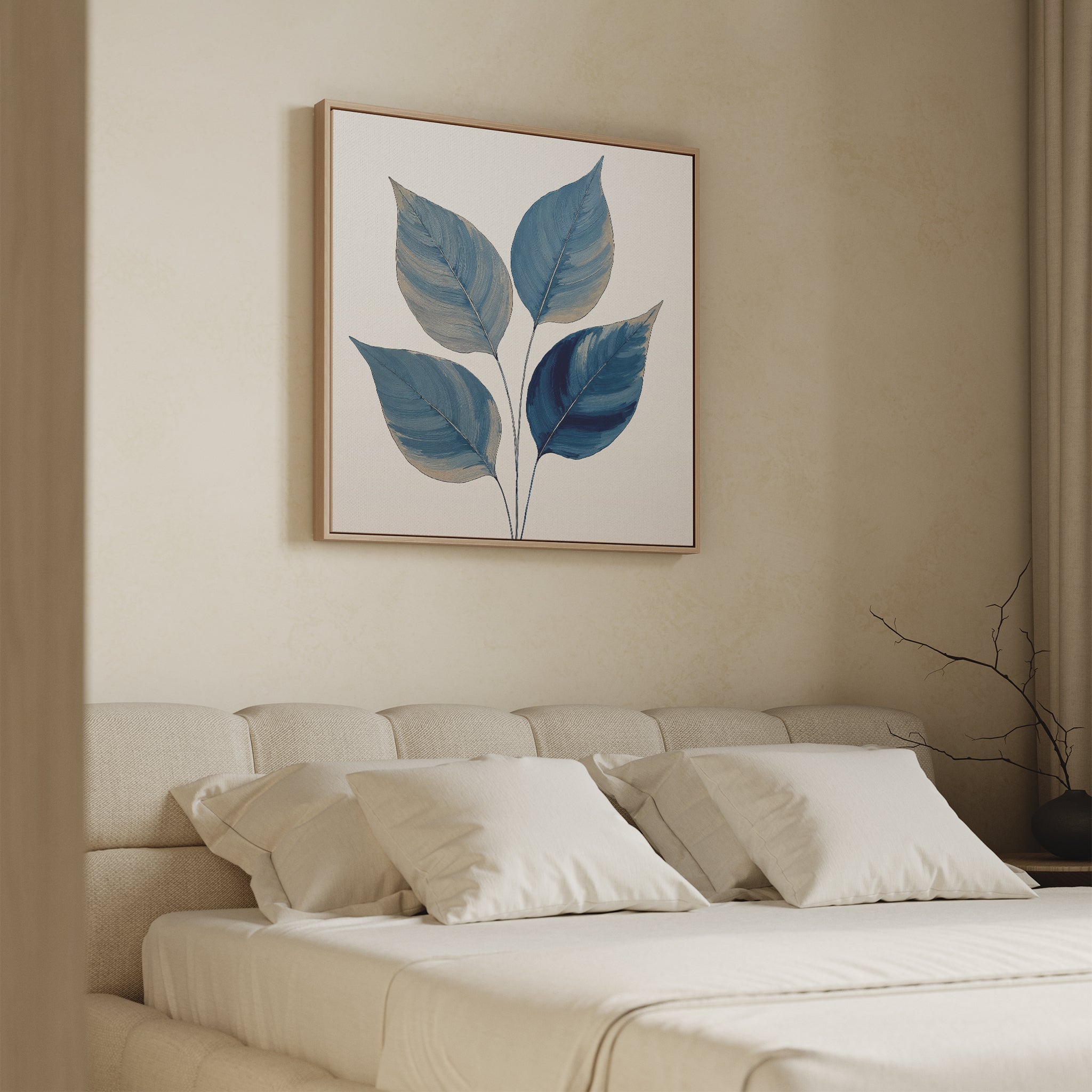 A minimalist bedroom with a beige bed, white pillows, and the Sapphire Leaves Canvas Art - Square showcasing blue botanical foliage above the headboard. A bare decorative branch rests on the bedside table.