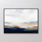 Sapphire Tides Canvas Art - Horizontal features soft brushstrokes and a white-gray sky above deep blue and tan hues, creating serene cobalt tones. This modern wall decor comes framed in black, ideal for hanging on a light-colored wall.