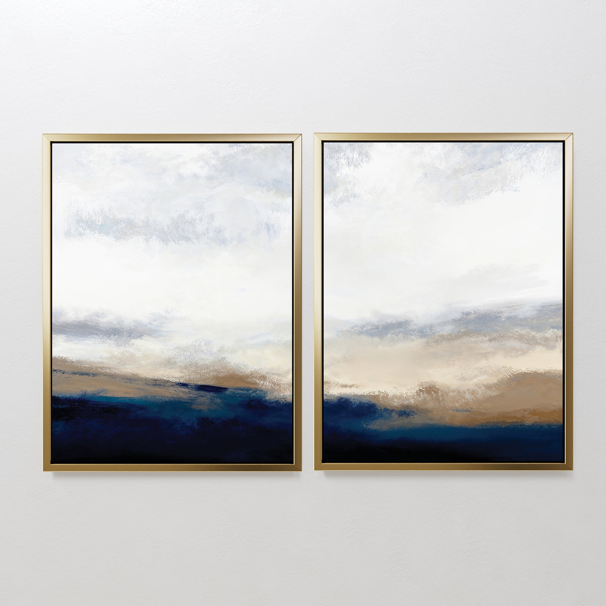 The Sapphire Tides - Set Of 2 features two abstract landscape paintings with gold frames, depicting cloudy skies above soft cobalt blues, beige, and white. Hung side by side, they’re ideal for modern living rooms.