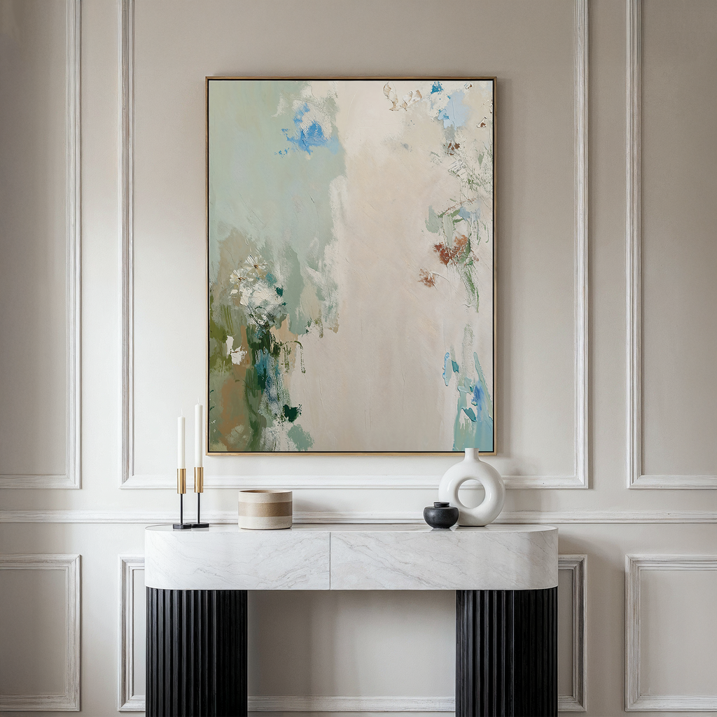 The Serenity Garden Abstract Canvas Art, with soft pastel tones, hangs above a marble console table adorned with candlesticks, a round box, black bowl, and white sculptural vase for an elegant, modern look.