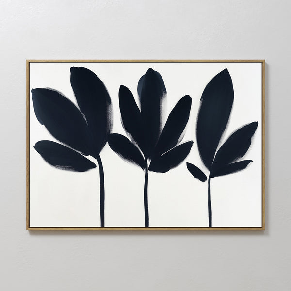 Shadow Stems Canvas Art - Horizontal features three abstract black botanical silhouettes with stems on a white background, framed in thin light wood. Its bold brushstrokes offer a modern touch, ideal for contemporary living rooms.