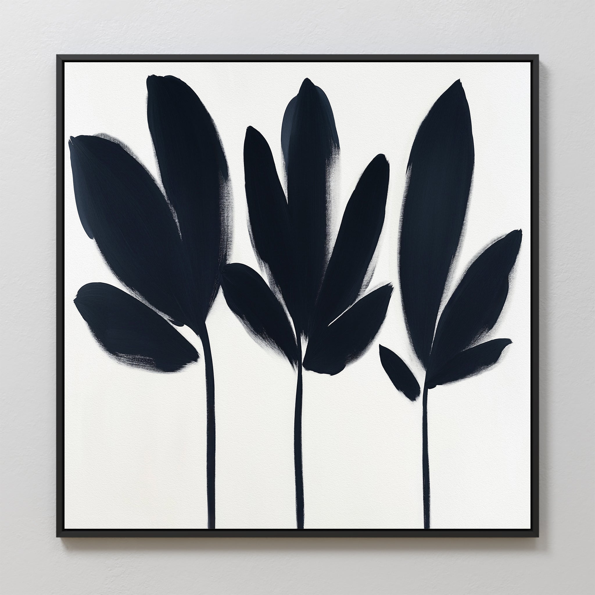 The Shadow Stems Canvas Art - Square showcases three abstract botanical silhouettes in bold black brushstrokes on a white background with a slim black border—ideal for contemporary living rooms.