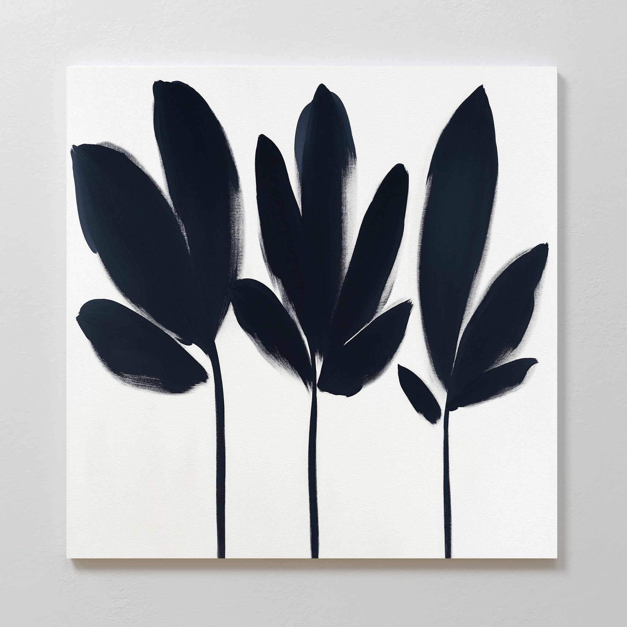 The Shadow Stems Canvas Art - Square features three black botanical silhouettes with elongated stems on a white background in a minimalist, abstract style—ideal for complementing modern living room décor.