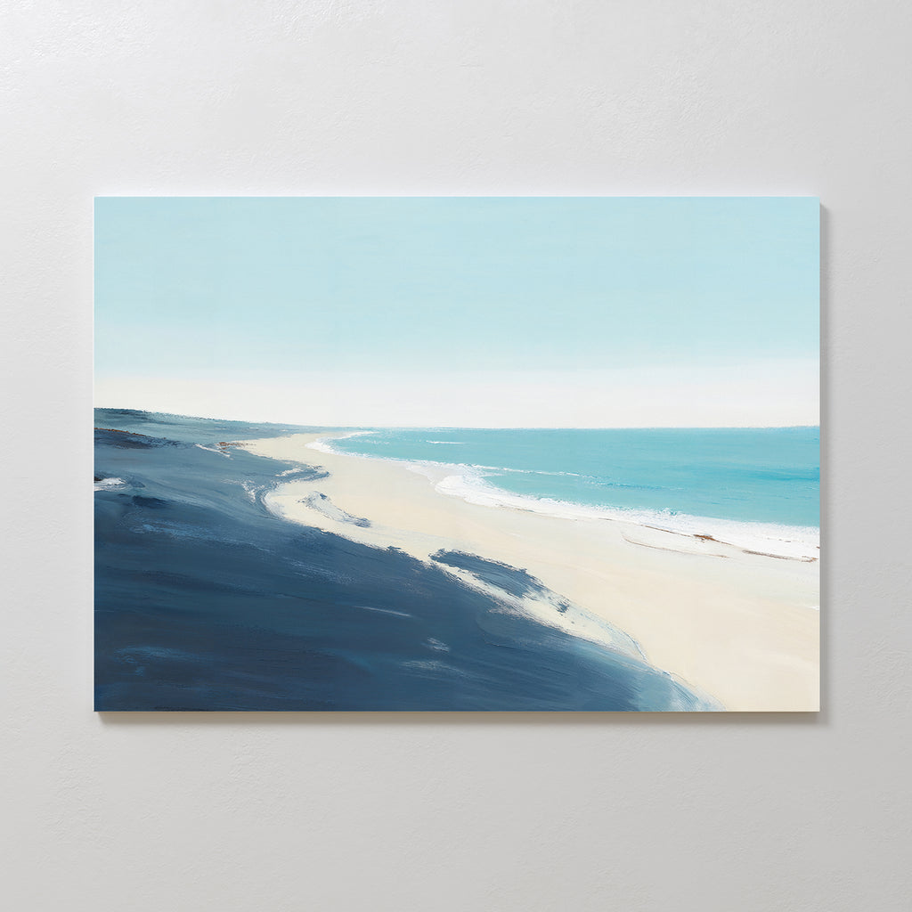 The Shifting Tides Canvas Art - Horizontal features a minimalist beach scene with pale sand, gentle waves, and a calm blue sea under a clear sky, accented by dark blue tones along the shore—a serene coastal wall art print.