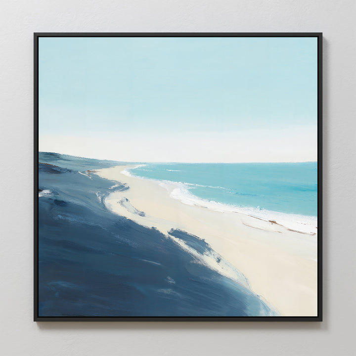 Shifting Tides Canvas Art - Square features a serene coastal scene with soft blue sky, turquoise ocean, and gentle waves meeting sandy shore, all viewed from above. Dominant dark blue and beige tones highlight the foreground coastline.
