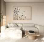 Minimalist living room featuring a light beige sectional, Nordic decor, wooden coffee table with dark bowl, soft natural light, and neutral tones. The serene space is completed by Silhouette Meadow Canvas Art - Horizontal and a leafy plant.