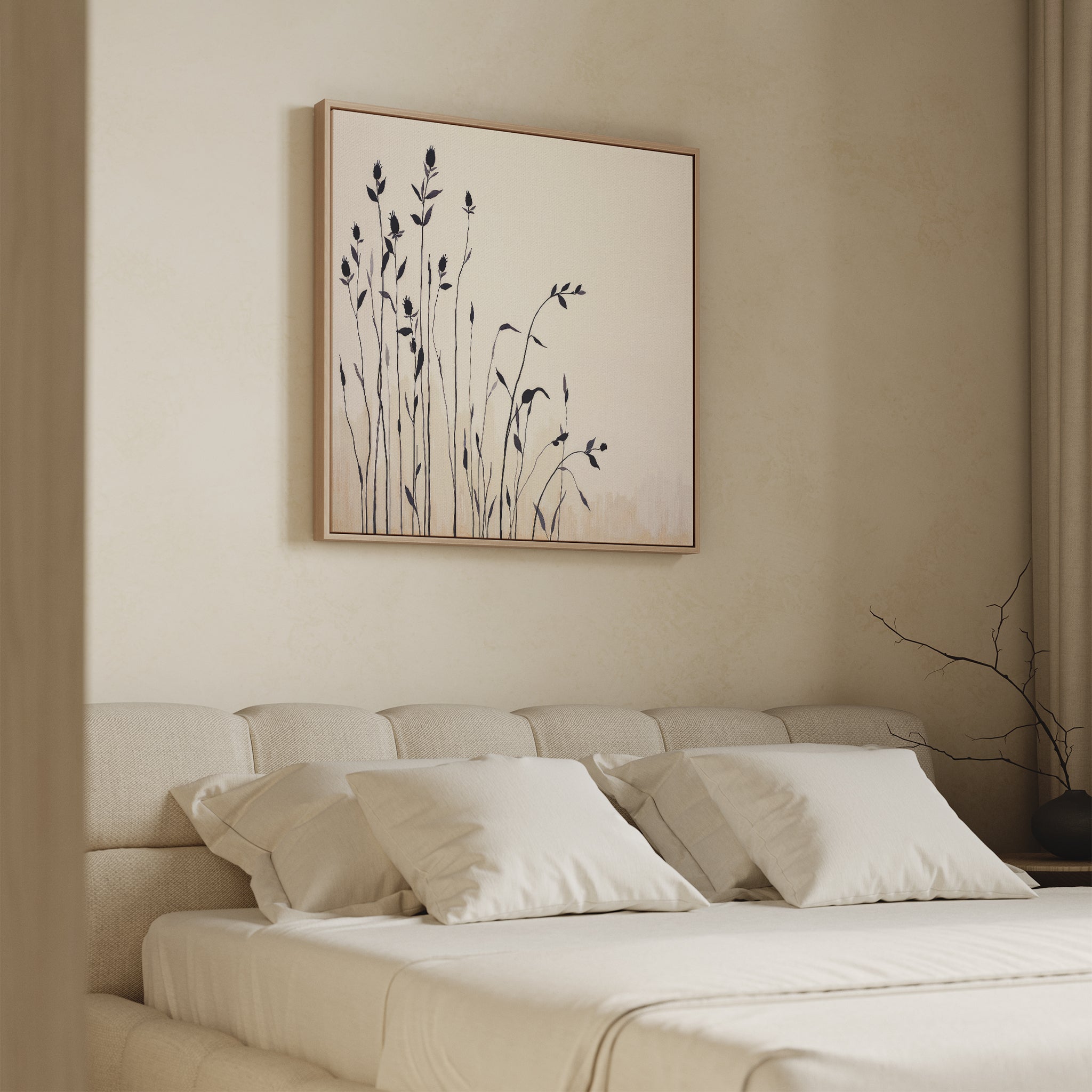 A cozy bedroom with a beige upholstered bed, four white pillows, and the Silhouette Meadow Canvas Art - Square featuring black botanical shapes above the headboard. Curtains and a bare branch in a vase complete the serene Nordic decor.