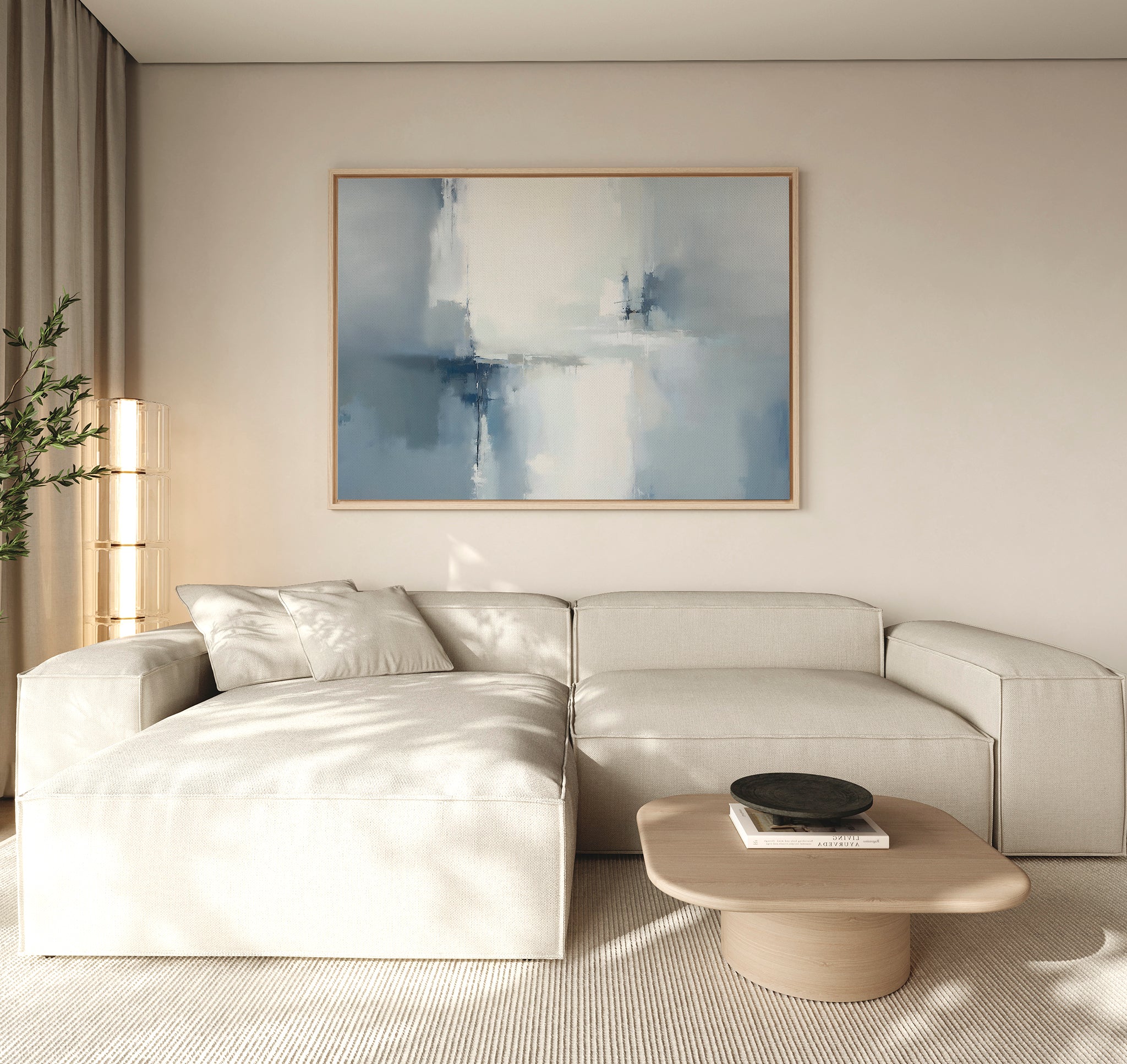 A modern living room with a light beige sectional, wooden coffee table, black bowl, tall plant, and the Silver Cross Formation Canvas Art - Horizontal featuring abstract blue and white tones on the wall. Natural light fills the space.