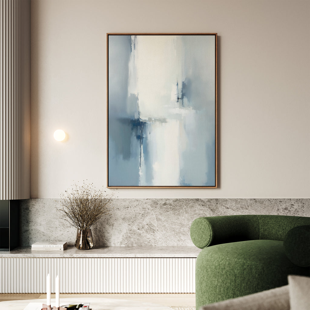 A modern living room with a green curved sofa, marble bench, and vase with dried branches is complete with the Silver Cross Formation Canvas Art - Vertical hanging above the bench.