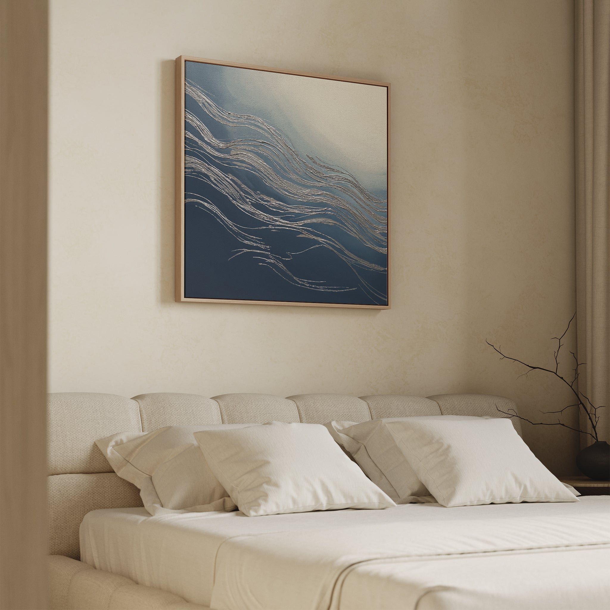 Minimalist bedroom with a low beige upholstered bed, white bedding, and a pale wall. Above the headboard hangs the Silver Current Canvas Art - Square. A bare branch on a side table adds contemporary sophistication.