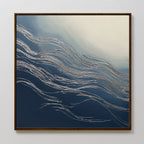 The Silver Current Canvas Art - Square features silver wavy lines over a blue and white gradient, evoking water or wind movement. Framed in thin dark wood, it brings contemporary sophistication to any light-colored wall.