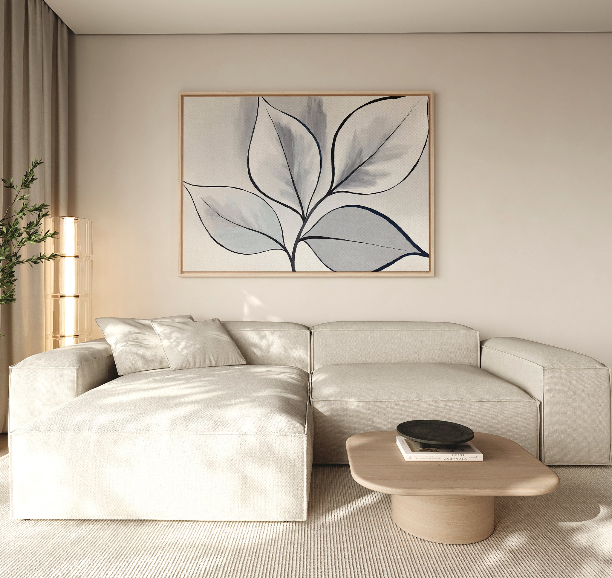 A modern living room features a light beige sectional, wooden coffee table with black bowl, neutral rug, tall plant, and the Silver Leaves Canvas Art - Horizontal on the cream wall. Perfect for modern decor lovers as sunlight softly filters in.