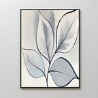 The Silver Leaves Canvas Art - Vertical features abstract leaf designs in black outline with soft gray, blue, and white fills. Displayed in a black frame on a light wall, it's perfect for modern home decor.