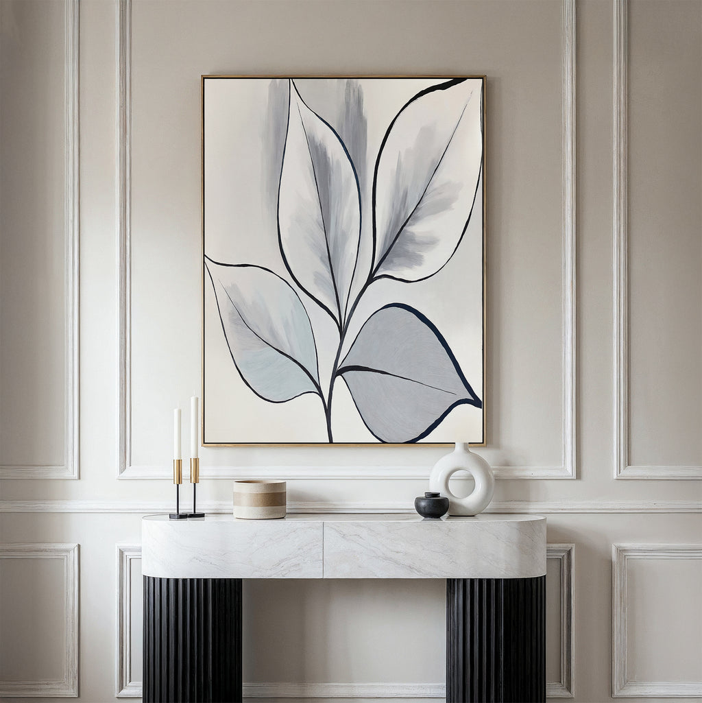 A minimalist modern entryway features a marble-top console table, decorative accents, and the Silver Leaves Canvas Art - Vertical in neutral tones on a light paneled wall for an elegant touch of modern home decor.