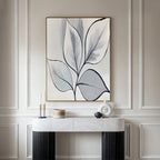A minimalist modern entryway features a marble-top console table, decorative accents, and the Silver Leaves Canvas Art - Vertical in neutral tones on a light paneled wall for an elegant touch of modern home decor.