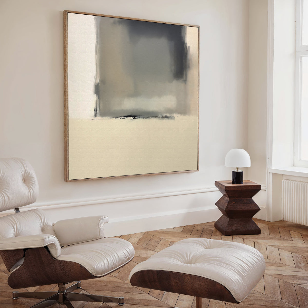 A modern living room features a cream leather lounge chair and ottoman, a small wooden side table with a white lamp, and Smoke Boundary Canvas Art - Square above. Light wood herringbone flooring completes the minimalist look.