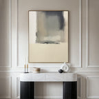A modern, minimalist room features light paneled walls and a marble console table with black legs. The Smoke Boundary Canvas Art - Vertical in neutral tones hangs above, complemented by candles and ceramic decor for added elegance.