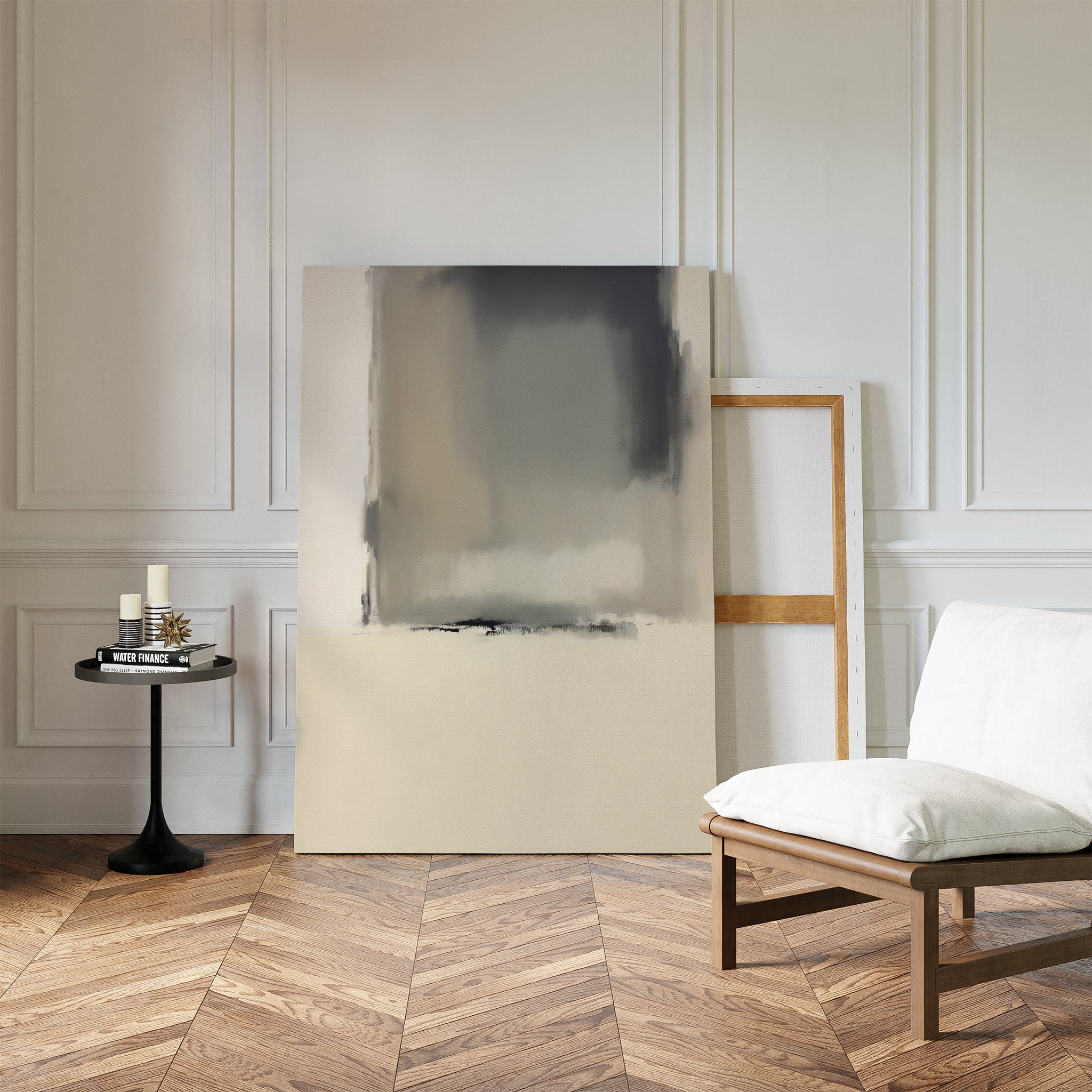 A minimalist room with herringbone wood floors, white paneled walls, a modern chair with white cushion, two large Smoke Boundary Canvas Art - Vertical prints leaning against the wall, and a small round black table with candles and a book.