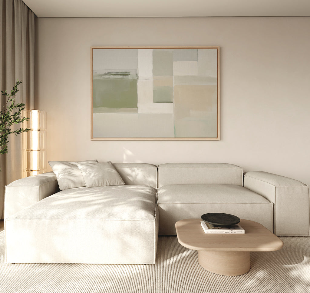 A modern living room featuring a light beige sectional, a low wooden coffee table with books and a bowl, neutral walls, sheer curtains, a tall plant in the corner, and Soft Geometric Planes Canvas Art - Horizontal on the wall.
