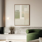 A modern living room features a green curved sofa, marble-topped bench, vase with dried branches, and the Soft Geometric Planes Canvas Art - Vertical in neutral tones on the light wall for a refined contemporary aesthetic.