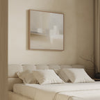 Minimalist bedroom with a beige upholstered bed, cream bedding, and four pillows. Above the bed hangs the Soft Layers Canvas Art - Square in neutral tones. A bare branch sits on the bedside, bathed in soft natural light.