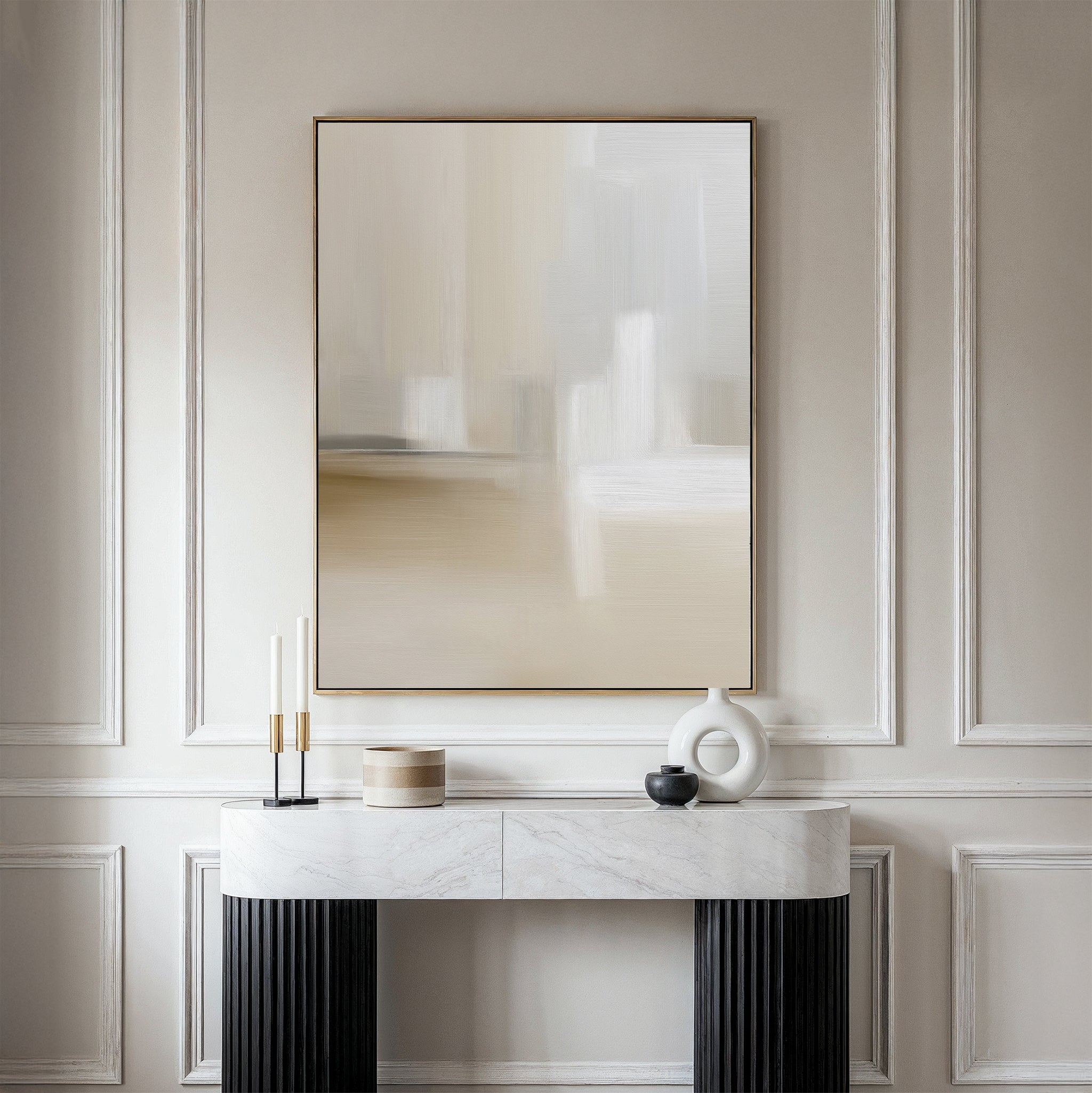 A minimalist console table with a marble top and black legs displays decor beneath the Soft Layers Canvas Art – Vertical on a taupe paneled wall in a modern, elegant room.