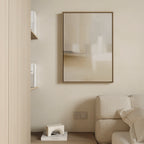 Minimalist living room corner with a beige sofa, Soft Layers Canvas Art - Vertical as neutral wall art, floating shelves holding books, and a small geometric decorative object on the floor. Neutral tones create a serene atmosphere.