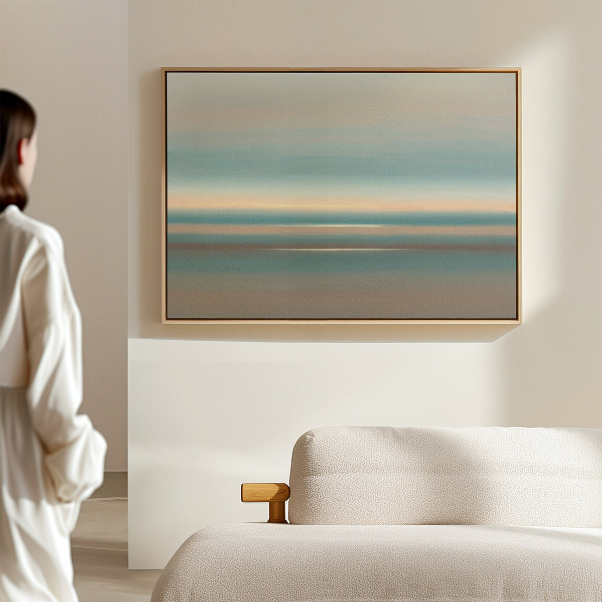 A person in white stands in a minimalist room, admiring the Soft Tide Layers Canvas Art—horizontal abstract layers of blue, teal, and beige above a light sofa—adding a tranquil Nordic Park vibe.