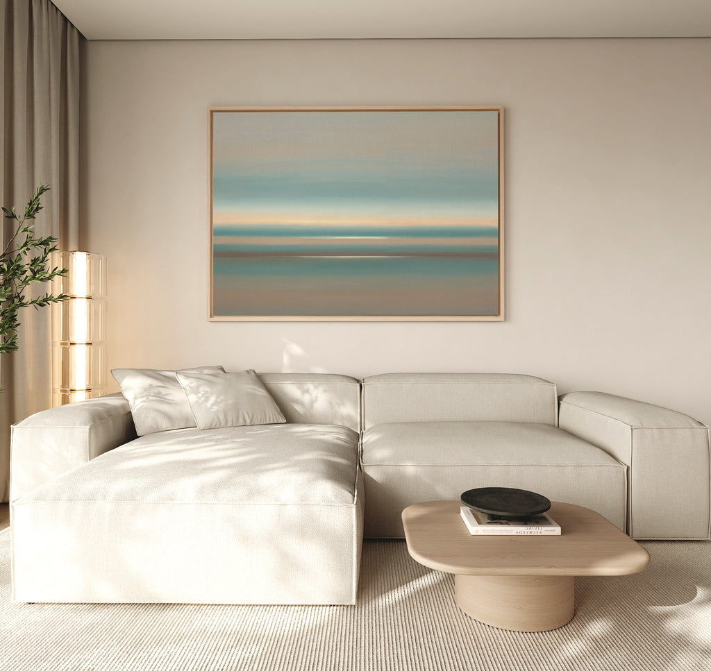 A modern living room with a light beige sectional, low wood coffee table, neutral decor, tall corner plant, and the Soft Tide Layers Canvas Art - Horizontal as coastal wall art creates a Nordic Park-inspired serene retreat.