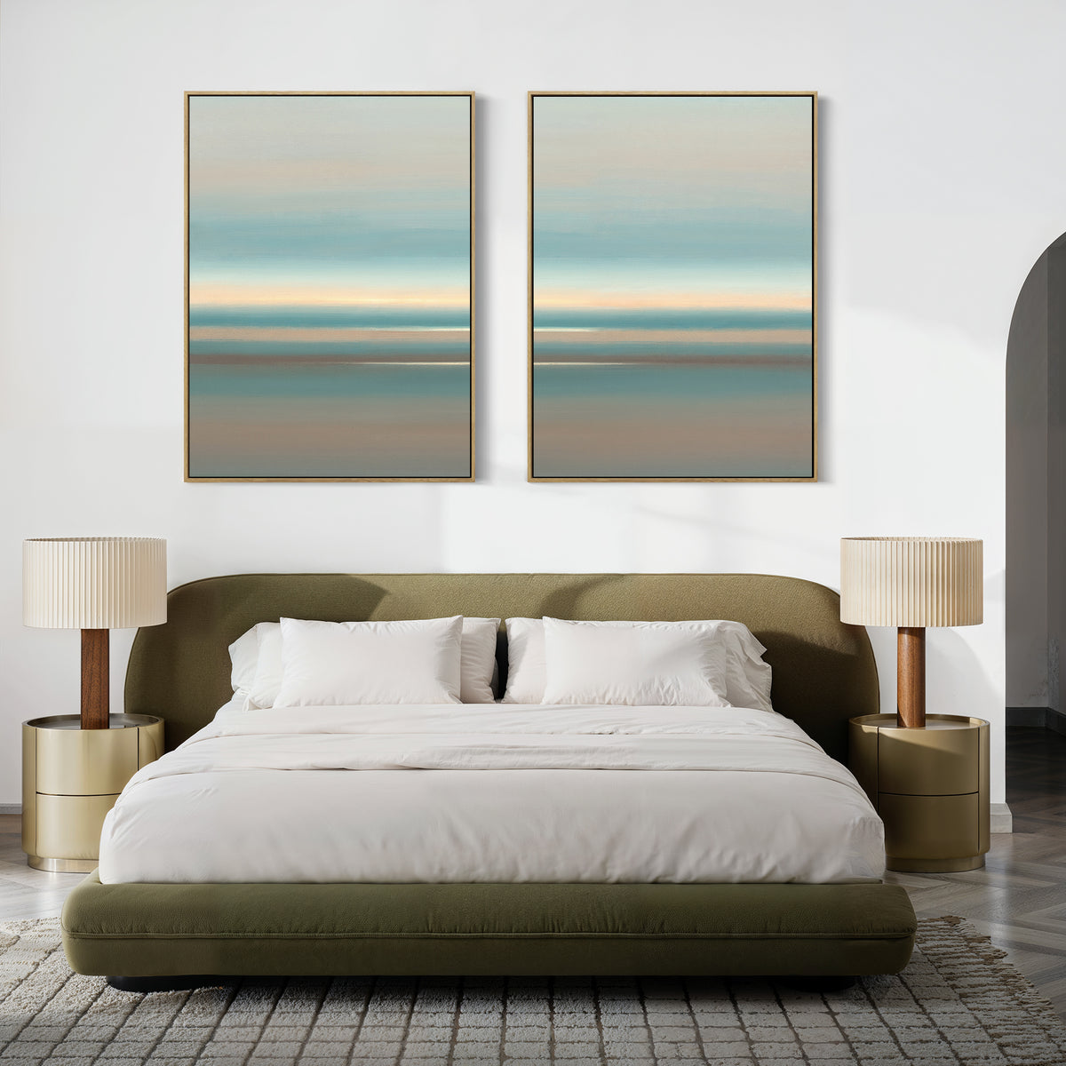 A modern bedroom with a green upholstered bed, white bedding, two gold nightstands with beige lamps, and the Soft Tide Layers - Set Of 2 calming abstract coastal wall art in soft blue and beige tones above the bed.