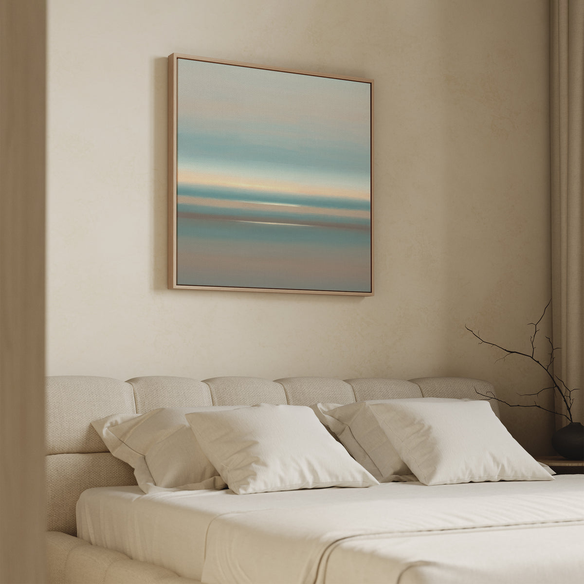 A minimalist bedroom features a beige upholstered bed with white bedding and pillows. Above the bed hangs the Soft Tide Layers Canvas Art - Square, showcasing calming blue, beige, and peach tones. A bare branch decorates the right nightstand.